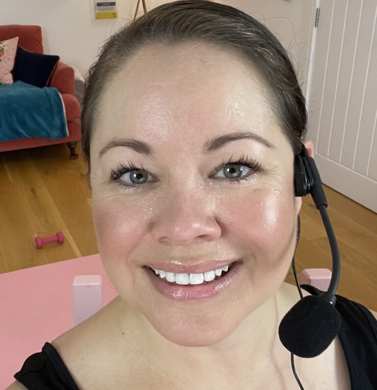 Headshot of Leanne smiling and glowing after teaching walkfit. Wearing a wireless headset microphone.