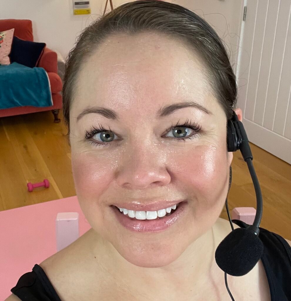 Headshot of Leanne smiling and glowing after teaching walkfit. Wearing a wireless headset microphone.