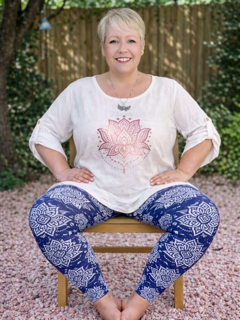 Callie sitting on a chair, wearing a white t-shirt and blue leggings with a white pattern.
